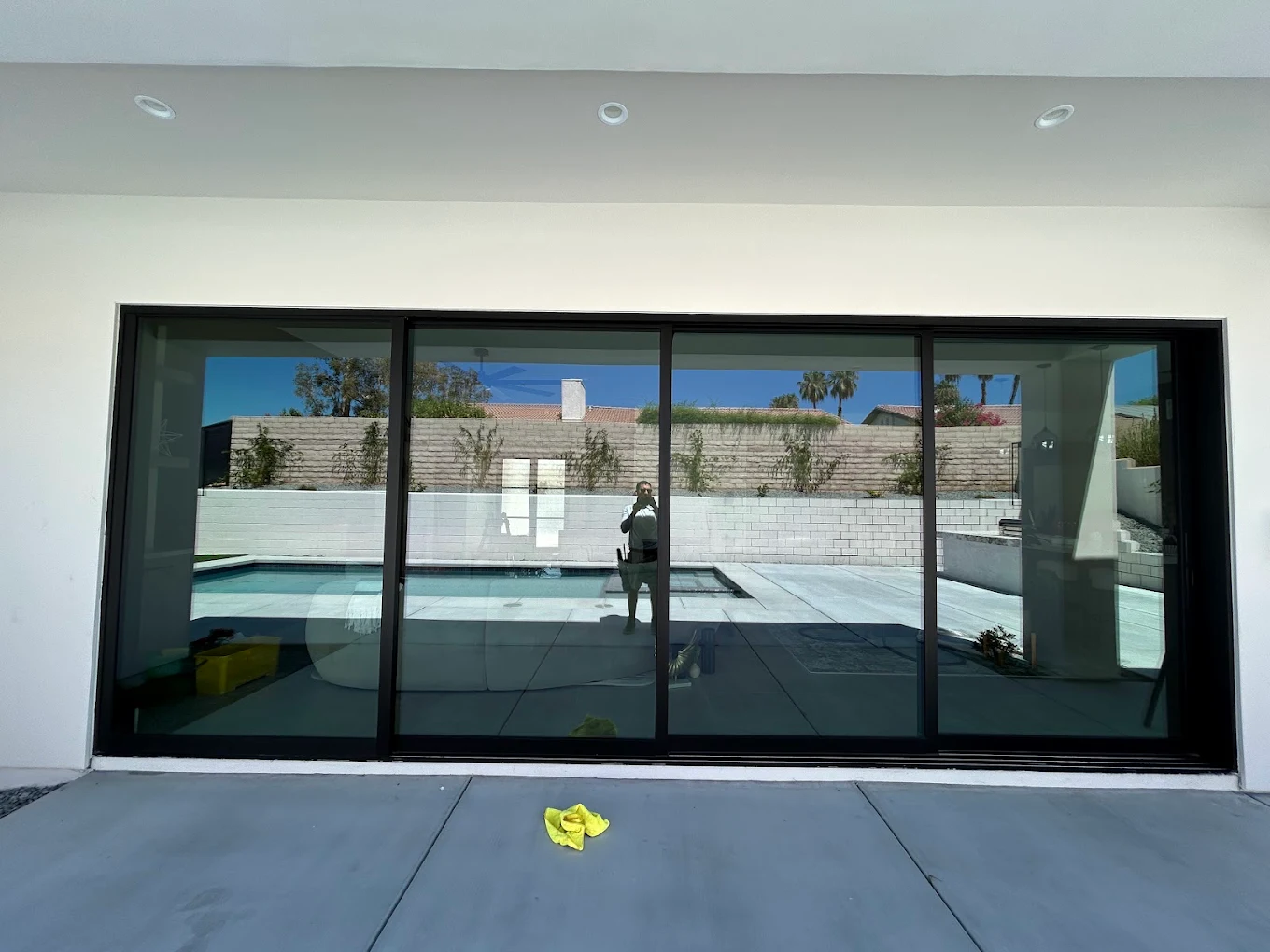 Glossy-cleaned floor-to-ceiling sliding glass doors reflecting a Palm Springs pool